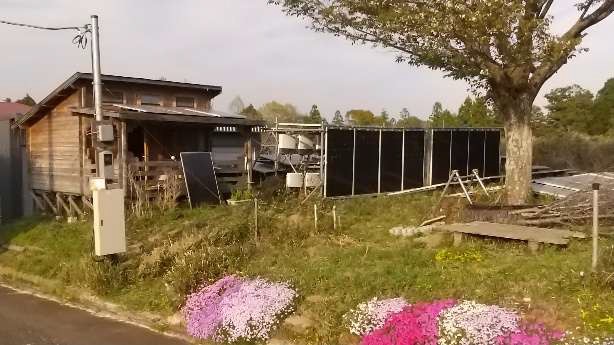 かすみがうらソーラー発電実証サイト：37.8kW土地有効利用型ソーラーと実証用ログハウスの外観